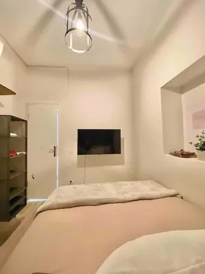 a white room with a bed and a flat screen tv at K&Y Apartments in Taksim 2 in Istanbul