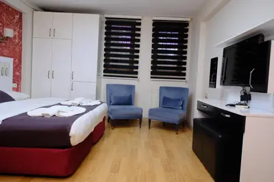 a bedroom with a bed and two blue chairs at ottogreensuit in Istanbul