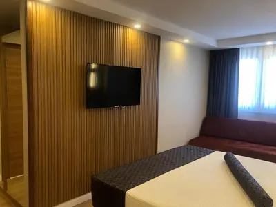 a bedroom with a bed and a television on a wall at Grand İska Palace in Istanbul