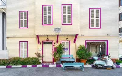 a pink and yellow house with a scooter parked in front at Alhambra Apart Hotel in Istanbul