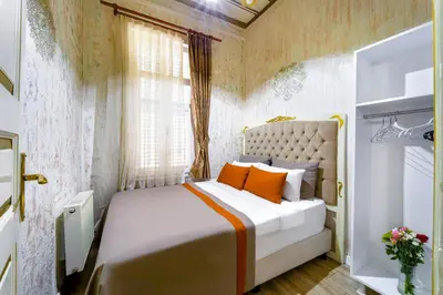 a bedroom with a bed with orange pillows and a window at Alhambra Apart Hotel in Istanbul