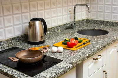 a kitchen counter with a pot and vegetables on a cutting board at Alhambra Apart Hotel in Istanbul
