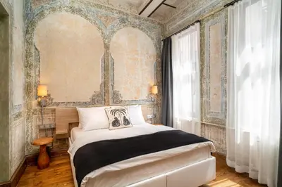 a bedroom with a bed in a room with a wall at Urban Quarters - Büklü Han in Istanbul