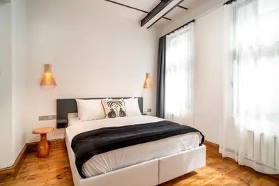a bedroom with a bed and a large window at Urban Quarters - Büklü Han in Istanbul