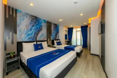 a hotel room with two beds and a painting on the wall at The Great Airport Hotel & Restaurant in Arnavutköy