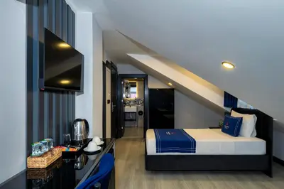 a bedroom with a bed and a staircase at The Great Airport Hotel & Restaurant in Arnavutköy