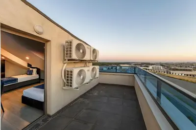 a balcony with a bed and two air conditioners at The Great Airport Hotel & Restaurant in Arnavutköy