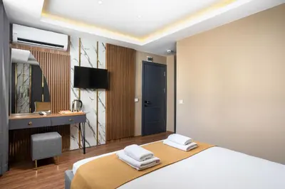 a bedroom with a bed and a desk and a mirror at Meridiani Taksim Hotel in Istanbul