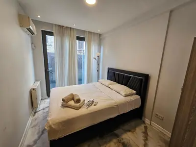 a bedroom with a bed with two towels on it at PERFECT RESİDENCE TAKSİM, 2 BEDROOM, POOL, Gym, Sauna in Istanbul