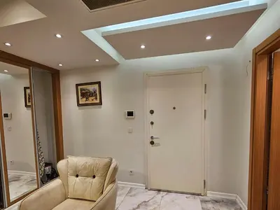 a living room with a chair and a door at PERFECT RESİDENCE TAKSİM, 2 BEDROOM, POOL, Gym, Sauna in Istanbul
