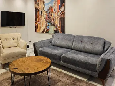 a living room with a couch and a table at PERFECT RESİDENCE TAKSİM, 2 BEDROOM, POOL, Gym, Sauna in Istanbul
