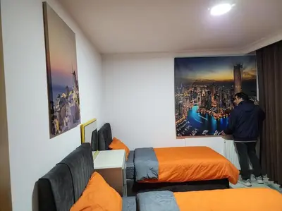 a man standing in a room with two beds at Taksim Square Residence, Two bedrooms, pool sauna gym in Istanbul