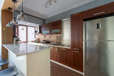 a kitchen with a stainless steel refrigerator and wooden cabinets at Exclusive Vibrant 3BR Duplex w Terrace in Kadıköy! in Istanbul