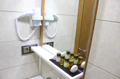 a bathroom with a shelf with bottles on it at Melidium Hotel in Beylikduzu