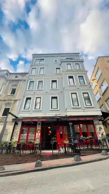 a large gray building with red doors on a street at Elegance House Hotel in Istanbul
