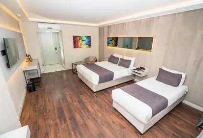 a hotel room with two beds and a desk at 216 Station Suite Gebze in Gebze