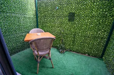 a chair sitting in front of a green fence at 216 Station Suite Gebze in Gebze