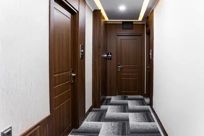 a corridor with wooden doors in a building at Mays Royal Hotel in Istanbul