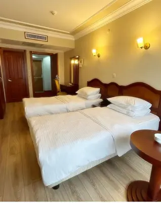 a hotel room with two beds and a table at Grand Hotel Seferoğlu in Istanbul