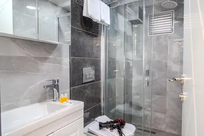 a bathroom with a shower and a toilet and a sink at Palladium APART Hotel in Istanbul