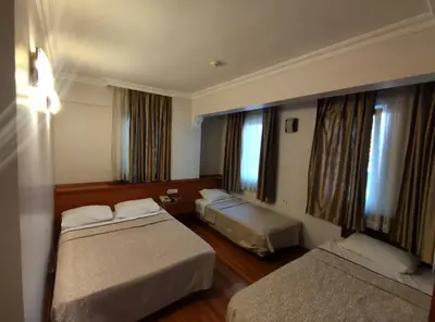 a hotel room with two beds and two windows at Hotel Nayla in Istanbul