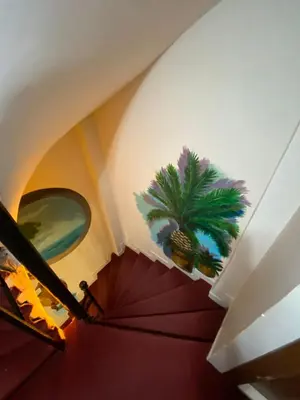 a staircase with an umbrella and a plant on the wall at Kadıköy Linda Hotel in Istanbul