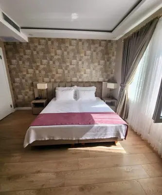 a bedroom with a large bed and two windows at Villa No 44 in Darıca