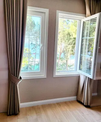 two windows with curtains in a room with wood floors at Villa No 44 in Darıca