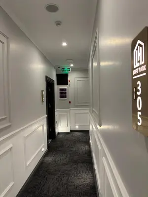 a hallway with white walls and a sign on the wall at Park Hotel & Private Transportation İstanbul Airport-By Loft in Arnavutköy