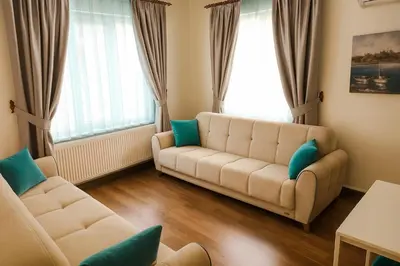 a living room with a couch and two windows at Istanberry - Berry Life Apartments in Istanbul