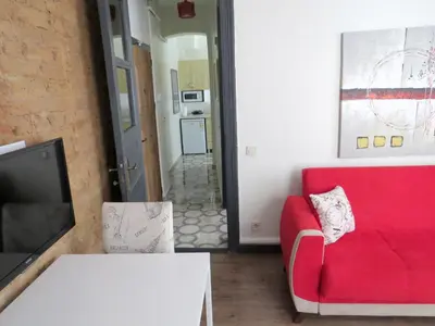 a living room with a red couch and a tv at Istanberry - Berry Life Apartments in Istanbul