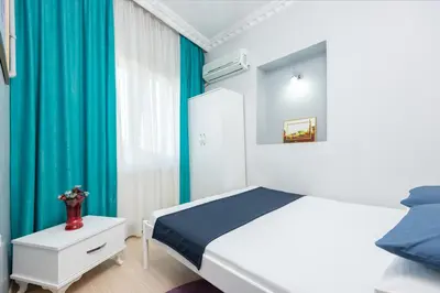a bedroom with a white bed and blue curtains at Istanbul House in Istanbul