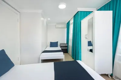 a bedroom with two beds and blue curtains at Istanbul House in Istanbul