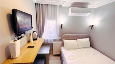 a hotel room with a couch and a tv at Taksim Centre Hotel in Istanbul