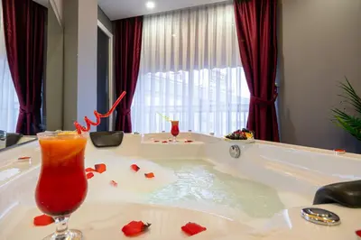 a bath tub with a drink in it with red roses at Viv City Hotel in Istanbul