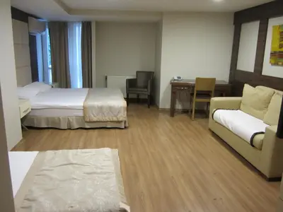 a hotel room with two beds and a couch and a table at Derpa Suite Hotel in Istanbul