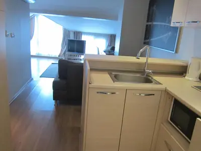 a kitchen with a sink and a living room at Derpa Suite Hotel in Istanbul