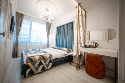 a bedroom with a bed and a mirror and a chair at Megalos Galata Hotel in Istanbul