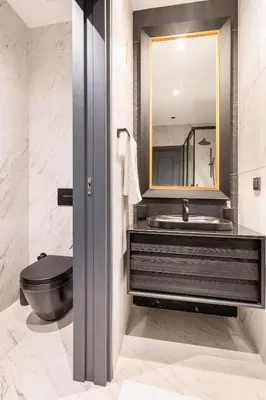 a bathroom with a black toilet and a mirror at Benesta Taksim No.8 in Istanbul