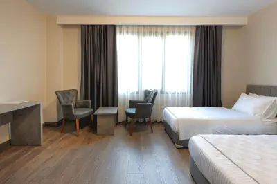 a hotel room with two beds and a desk and chairs at GRANDROYAL HOTEL in Gümüşyaka