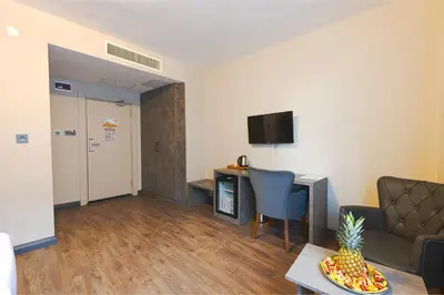 a living room with a couch and a table and a television at GRANDROYAL HOTEL in Gümüşyaka