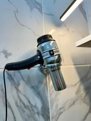a blow dryer is attached to a glass wall at pilot hotel in Arnavutköy