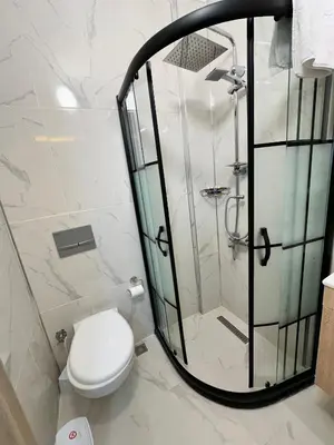 a bathroom with a toilet and a glass shower at pilot hotel in Arnavutköy