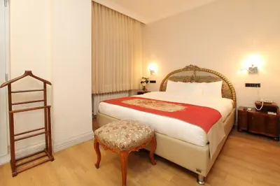 a bedroom with a large bed and a stool at Lir Residence Suites LONG STAY in Istanbul