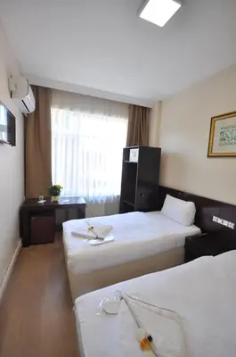 a hotel room with two beds and a window at Hotel Baykal in Istanbul