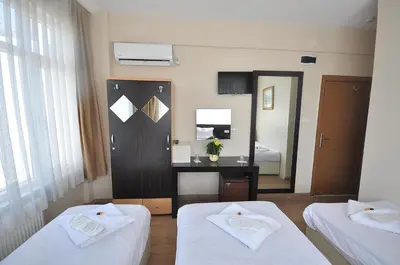 a hotel room with two beds and a mirror at Hotel Baykal in Istanbul