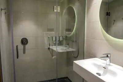 a bathroom with a shower and a sink and a mirror at Hampton By Hilton Sakarya in Sakarya