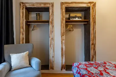 a blue chair in a room with two mirrors at Ali Pasha Apartment in Istanbul