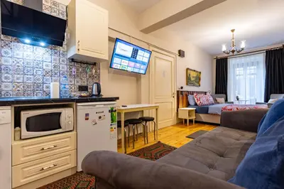 a kitchen and a living room with a couch and a tv at Ali Pasha Apartment in Istanbul