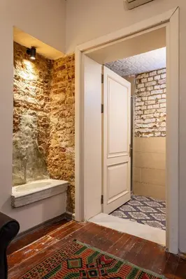 an open door in a bathroom with a brick wall at Ali Pasha Apartment in Istanbul
